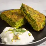 Delicious kuku sabzi on a plate with yogurt