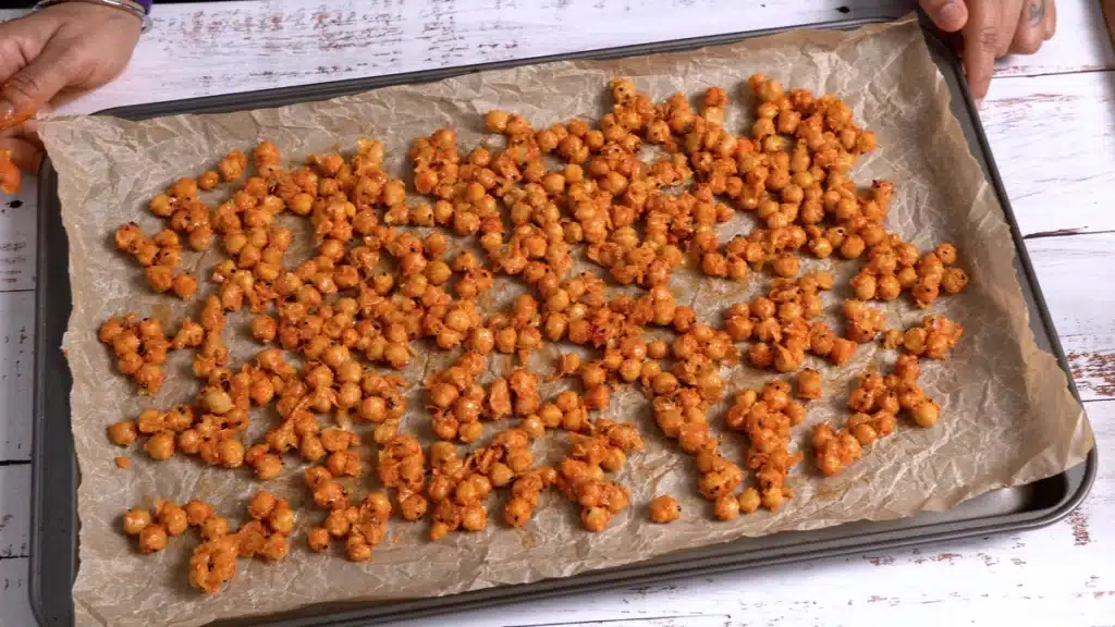 Baked Chickpeas - Better Than Popcorn spread coated chickpea on a baking tray
