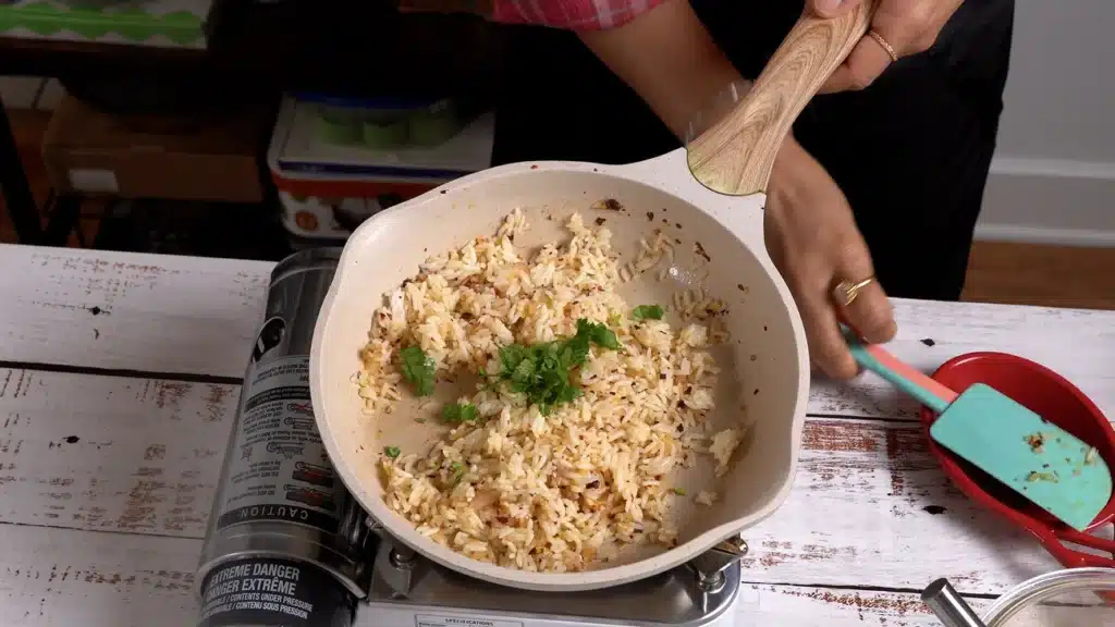 add cooked rice, salt and coriander and spread across pan