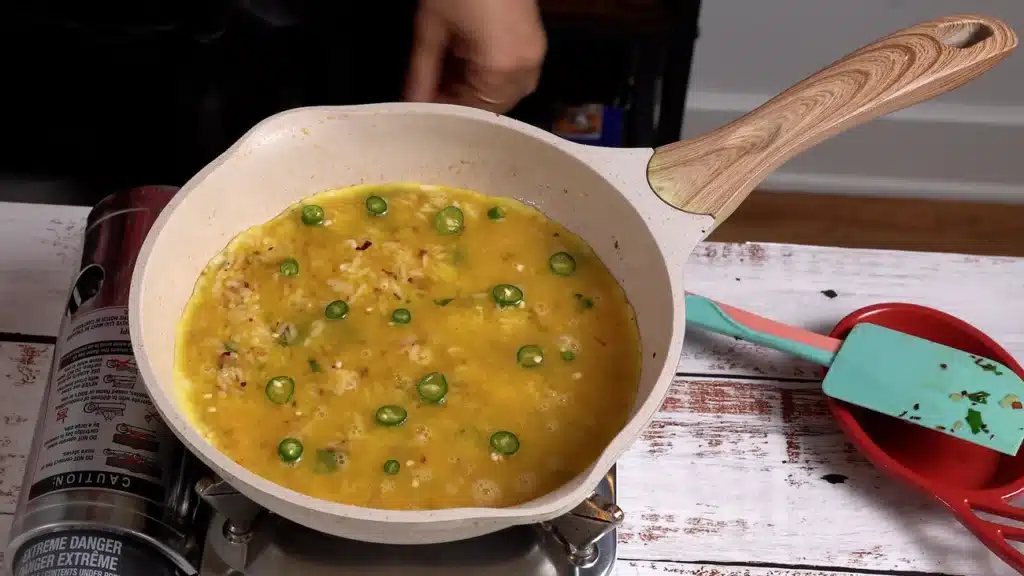 pour egg on top of rice and add green chili