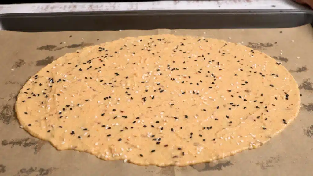 The Easiest Lentil Crispy Crackers: Delicious & Healthy Side spread a thin layer on parchment paper lined baking tray. sprinkle black and white sesame on top