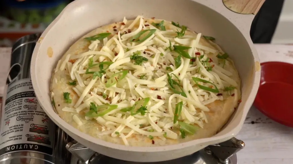 Cheesy Tortilla Omelette: Quick 15-Minute Recipe flip and add cheese and seasoning on top