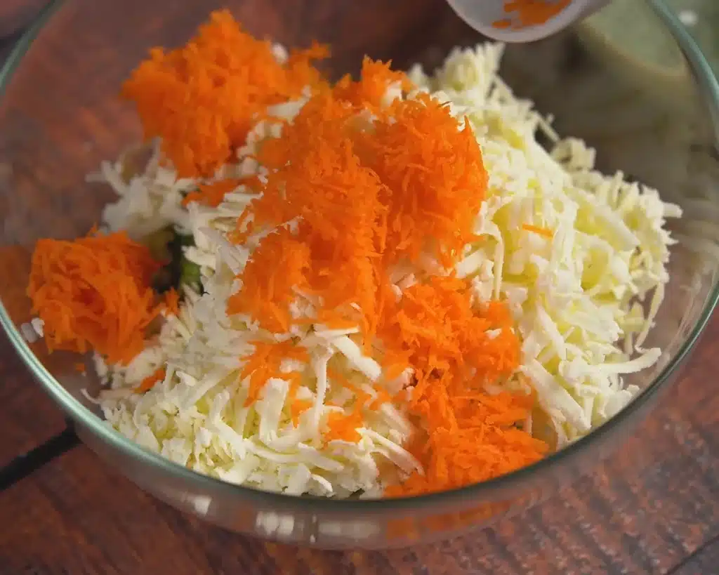 Grate your fresh carrots, cabbage, and cottage cheese into a large bowl