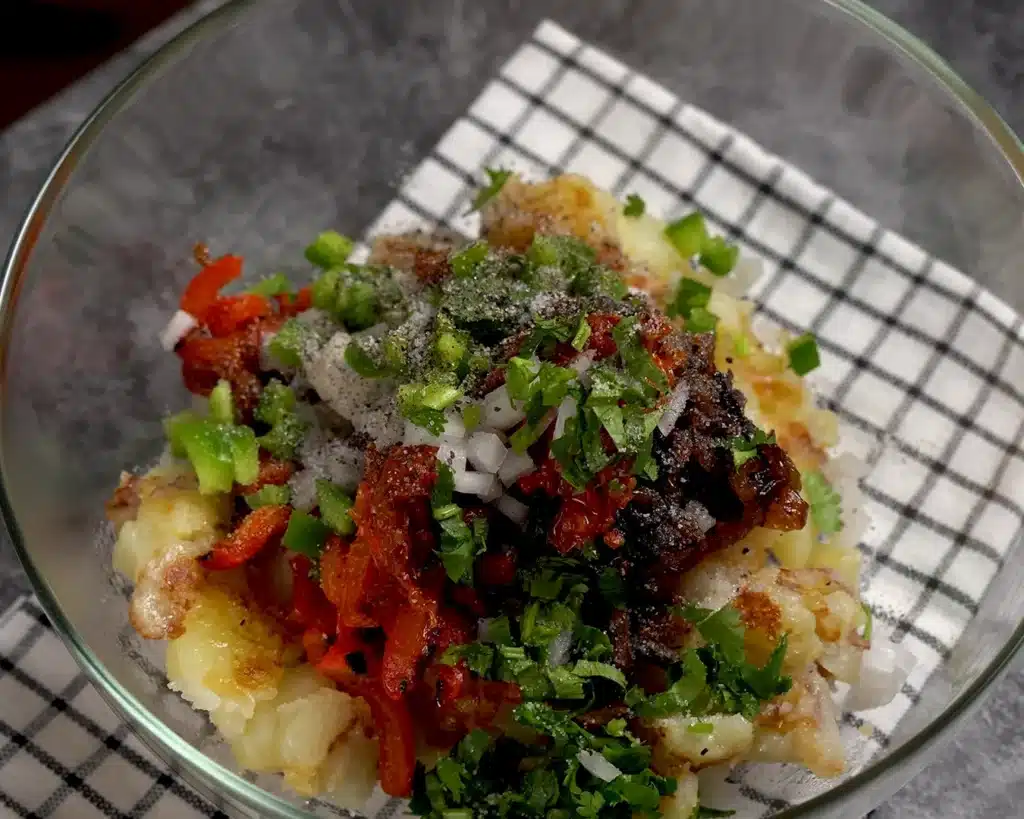 Vegetable Casserole: A Cheesy Dinner Recipe Mix the warm potatoes with the caramelized mushrooms, caramelized onions, roasted red bell peppers, sun-dried tomatoes, chopped onions, chopped bell peppers, coriander, black pepper and salt.