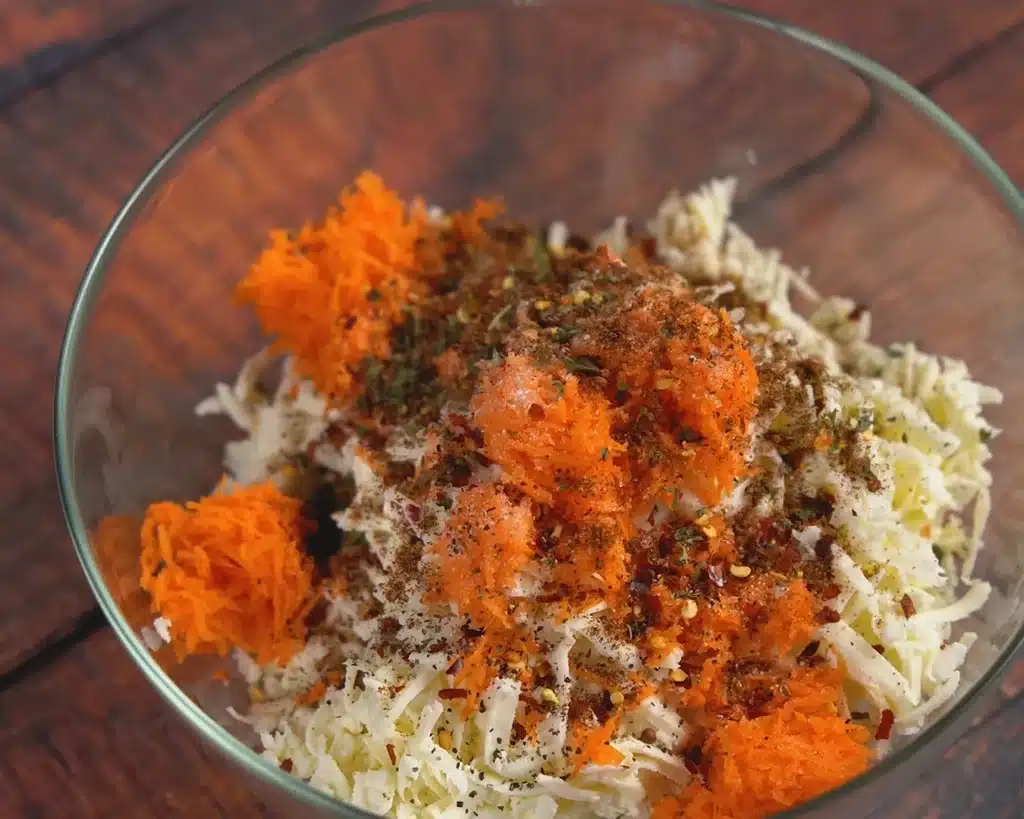 Add salt, sugar, chili flakes, BBQ seasoning, dry parsley and on the grated vegetables, cheese, and hung curd.