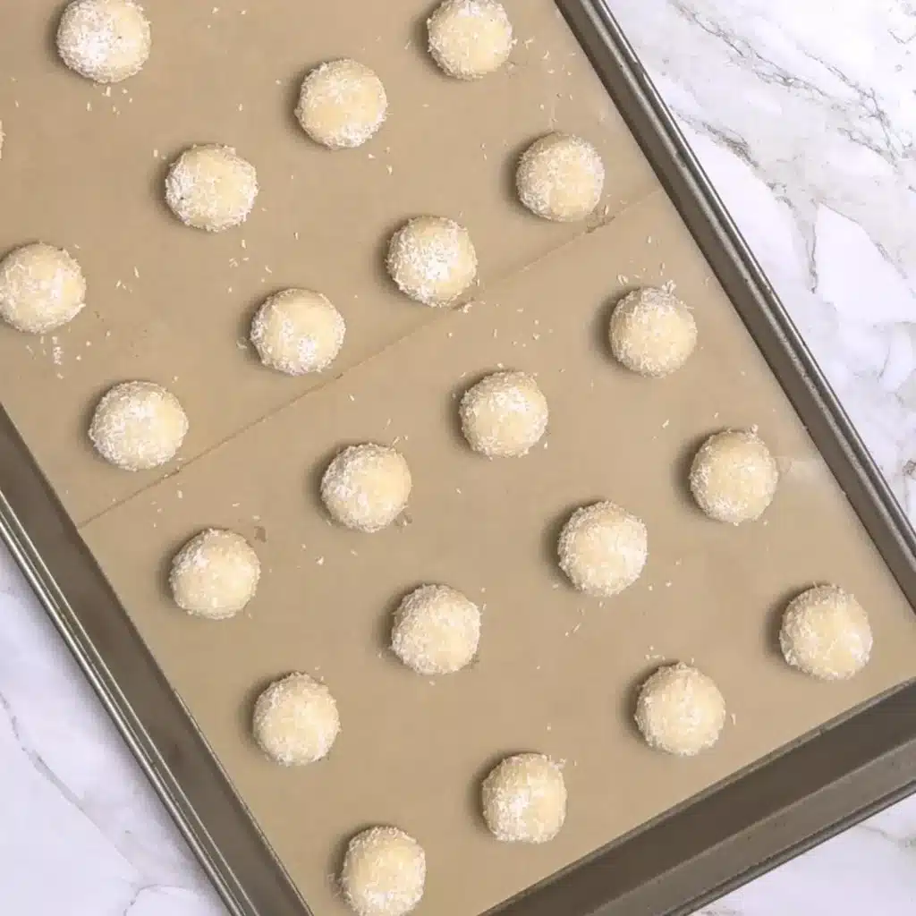 Best Coconut Tea Biscuits for Your Next Cup of Tea roll the balls , coat them well and place in baking tray
