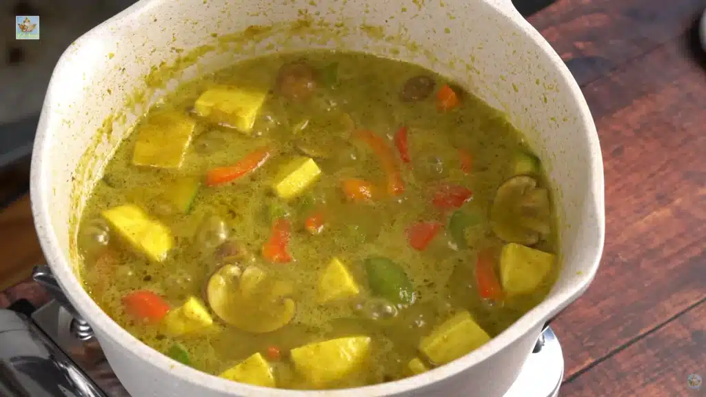Drop in the green and red bell peppers, zucchini, tofu, and mushrooms. Let the curry boil again and cook these vegetables for 4 to 5 minutes so they soften slightly.