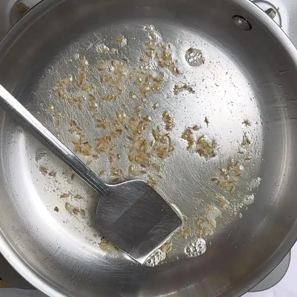 Easy Slow Cooker Creamy Lentils Recipe in a pan heat ghee add cumin seeds