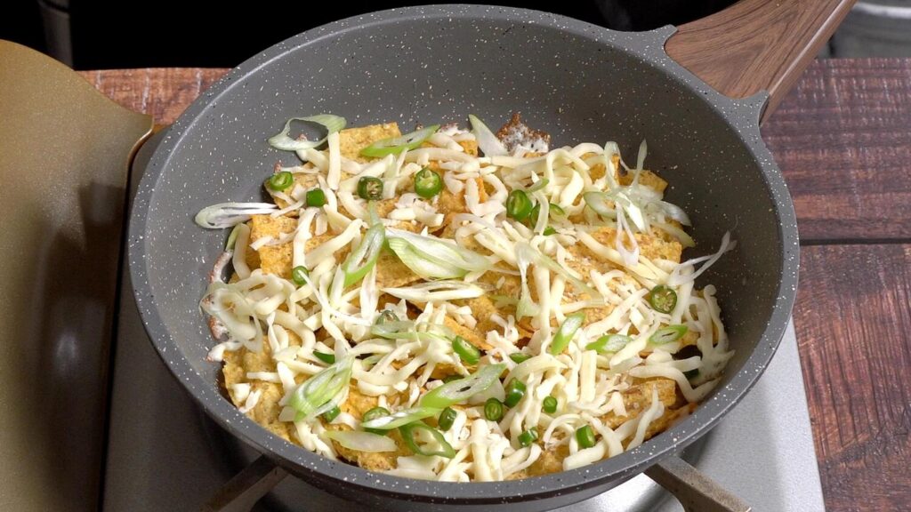 in a pan, spread chips and top with onion, cheese