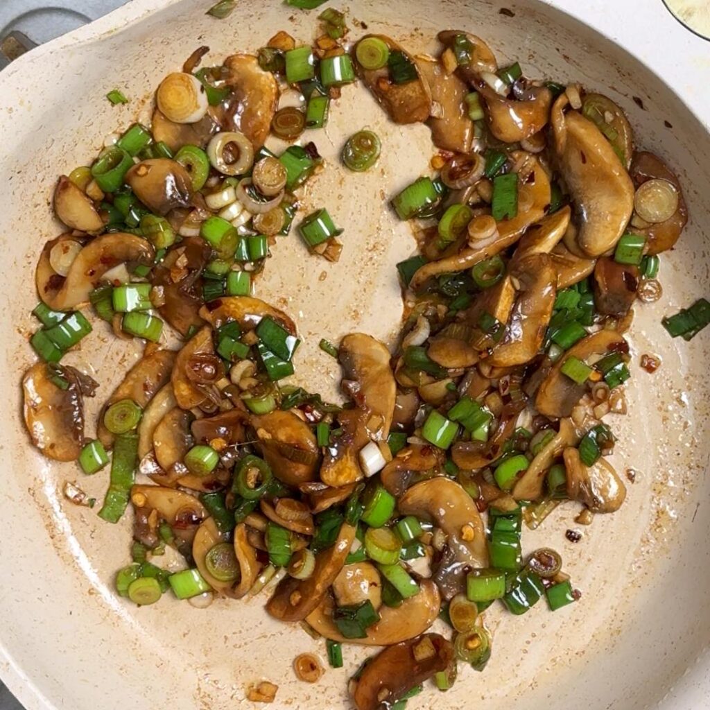 Now add the green onion, salt, chili flakes, soy sauce and crispy chili