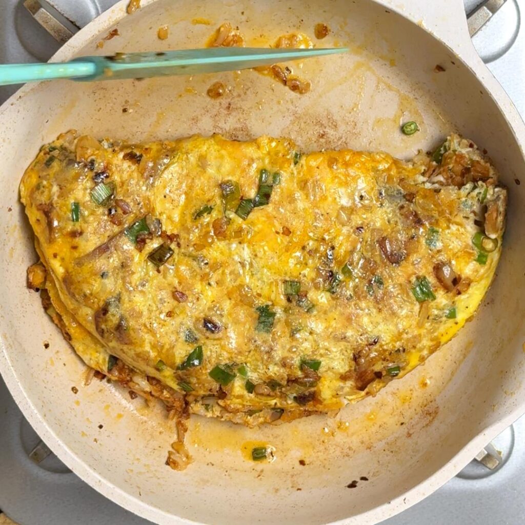 Now fold the other half of the omelette over the cheese then let it cook for a few seconds