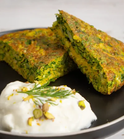 Delicious kuku sabzi on a plate with yogurt